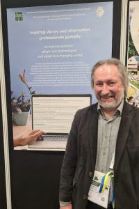 Alan in front of poster