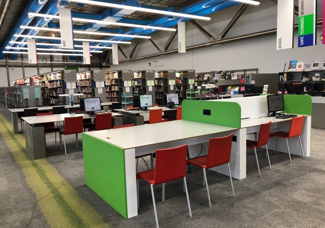 Horizontal view of Bpi with tables and chairs in open space.